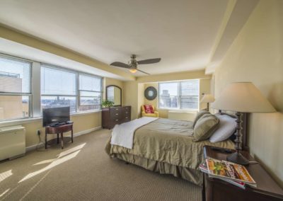 Furnished master bedroom with Philadelphia city views in Rittenhouse Claridge apartment
